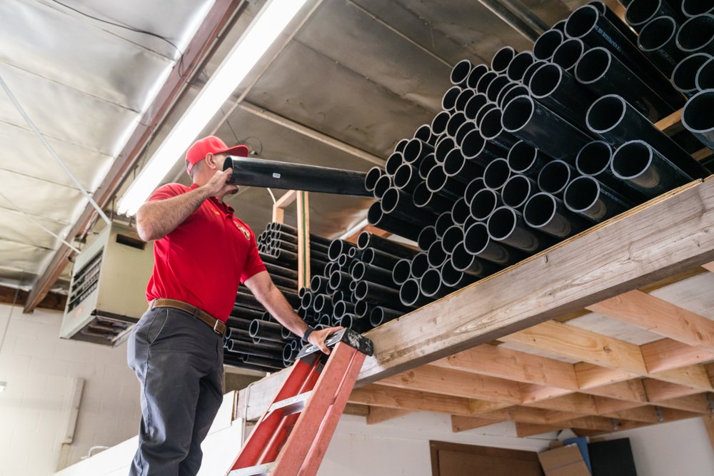 Hard Hat Rooter plumber working on overhead pipes