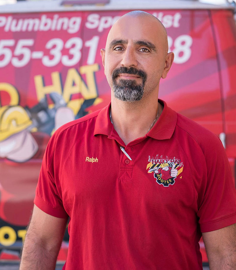Ralph, owner of Hard Hat Rooter and Plumbing, in front of a company van
